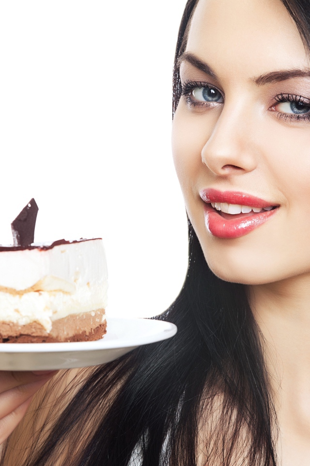 Красивая брюнетка с куском торта на блюдце