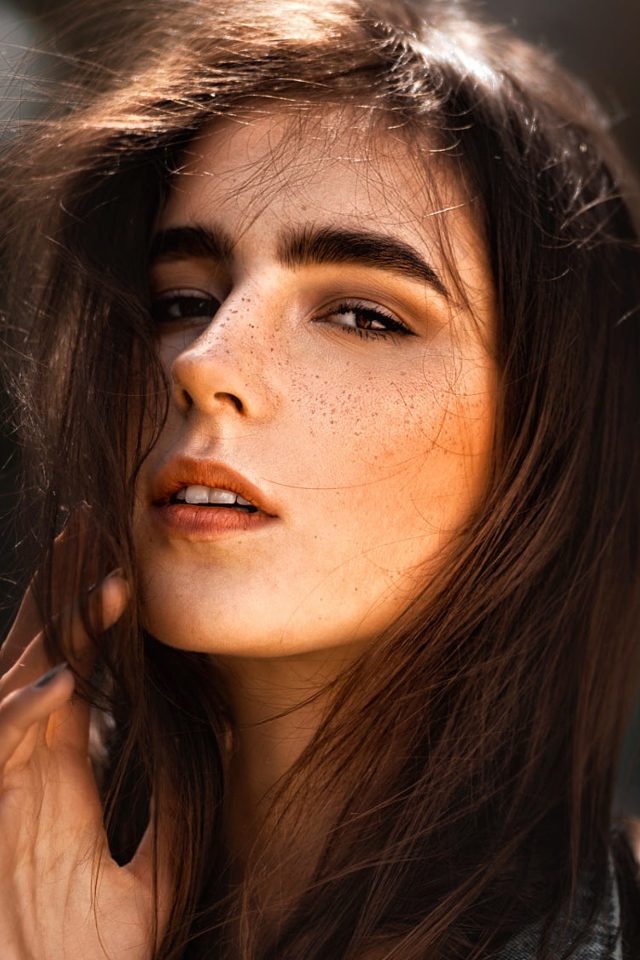 Красивая брюнетка с веснушками на лице