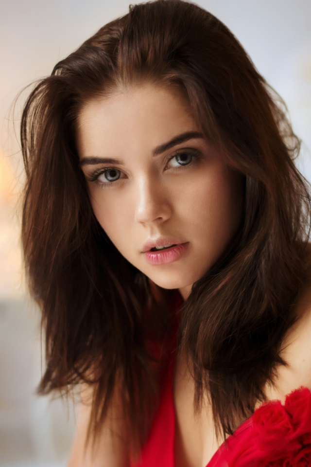 Красивая нежная длинноволосая брюнетка в красном