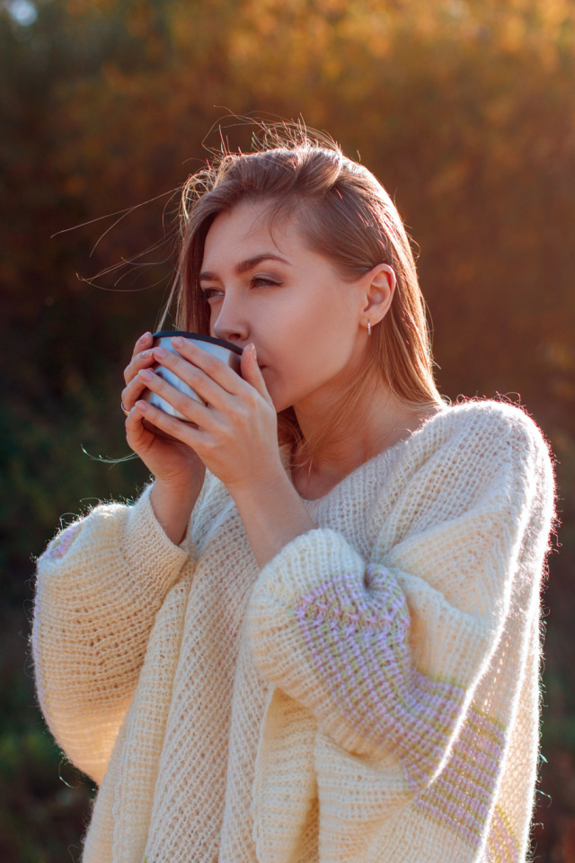 Красивая девушка пьет чай в теплом свитере
