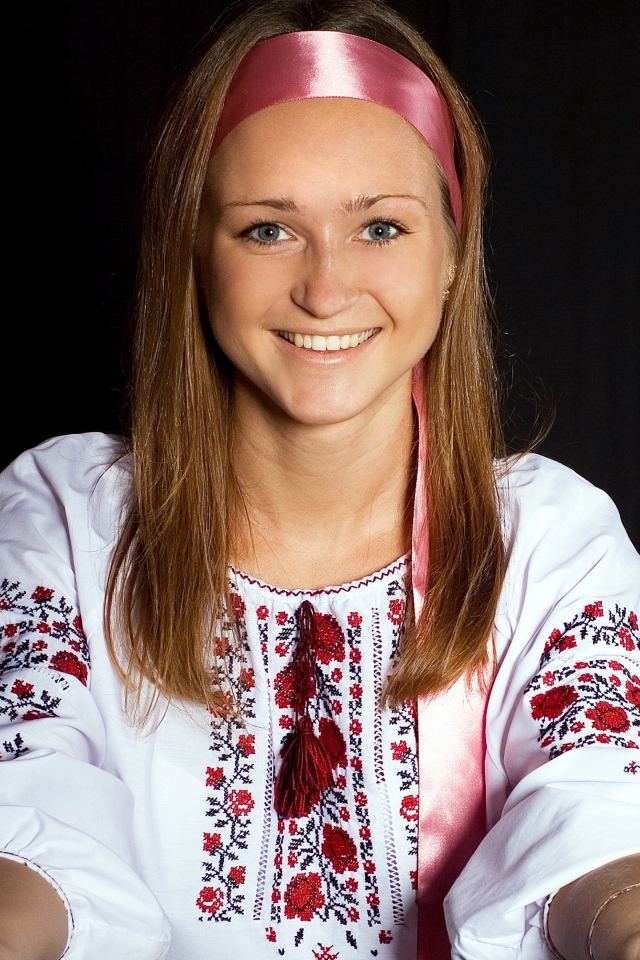 Красивая девушка в вышитой рубашке на черном фоне