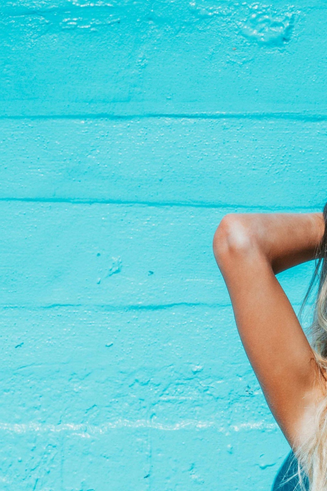 Красивая девушка в солнечных очках загорает на солнце летом