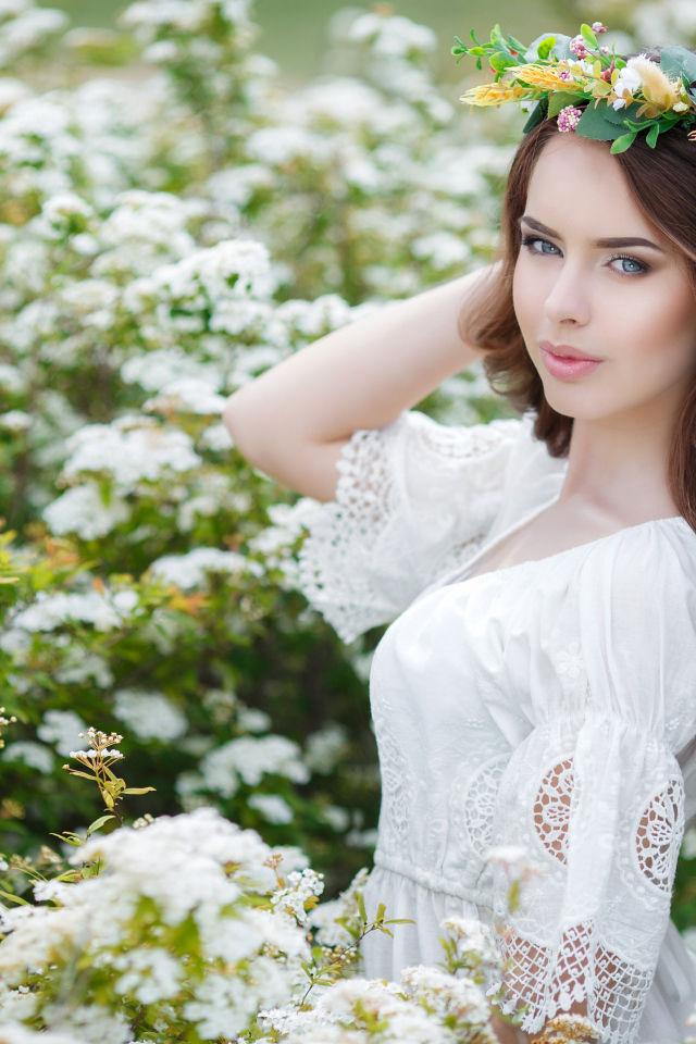 Красивая девушка в белом платье среди цветущих белых цветов