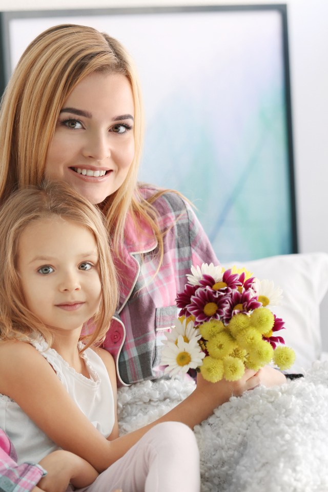 Красивая девушка с маленькой девочкой и букетом цветов