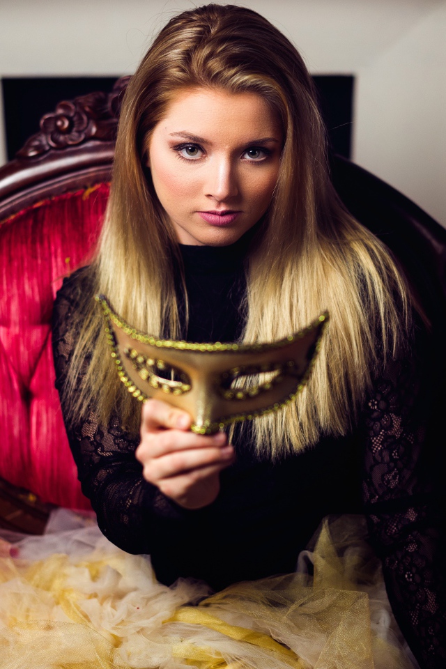 Красивая девушка с маской в руках