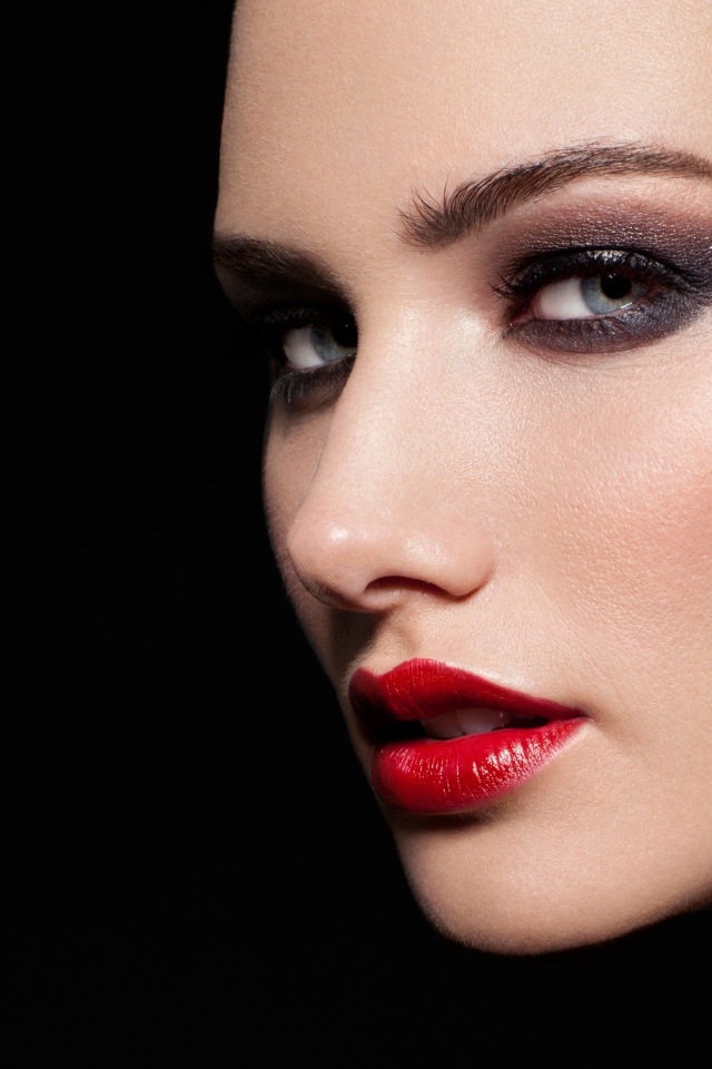 Красивая девушка с яркой помадой на губах на черном фоне