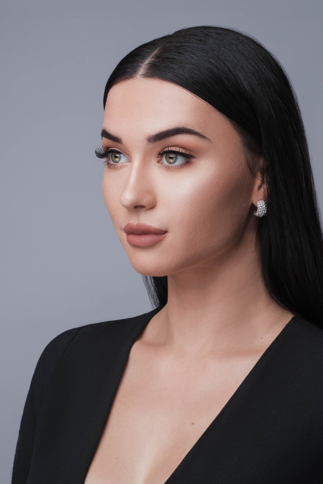 Красивая длинноволосая брюнетка в черном фото на сером фоне