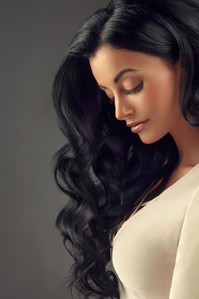 Красивая длинноволосая брюнетка на сером фоне