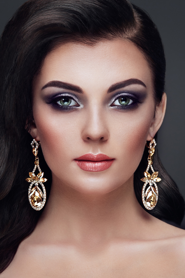 Красивая длинноволосая девушка с ярким макияжем и длинными серьгами