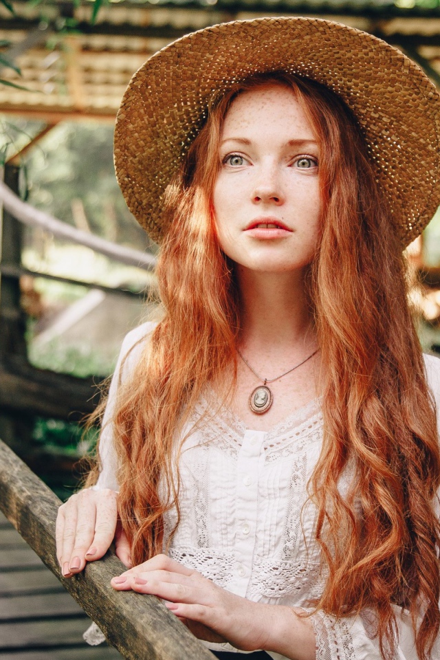 Красивая рыжеволосая девушка в соломенной шляпе