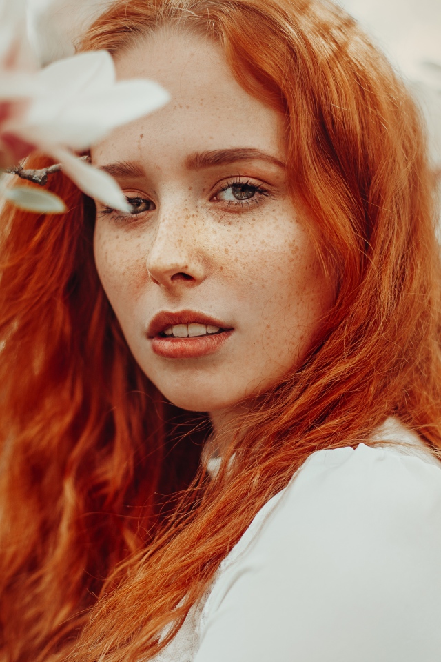 Красивая рыжеволосая девушка с веснушками на лице