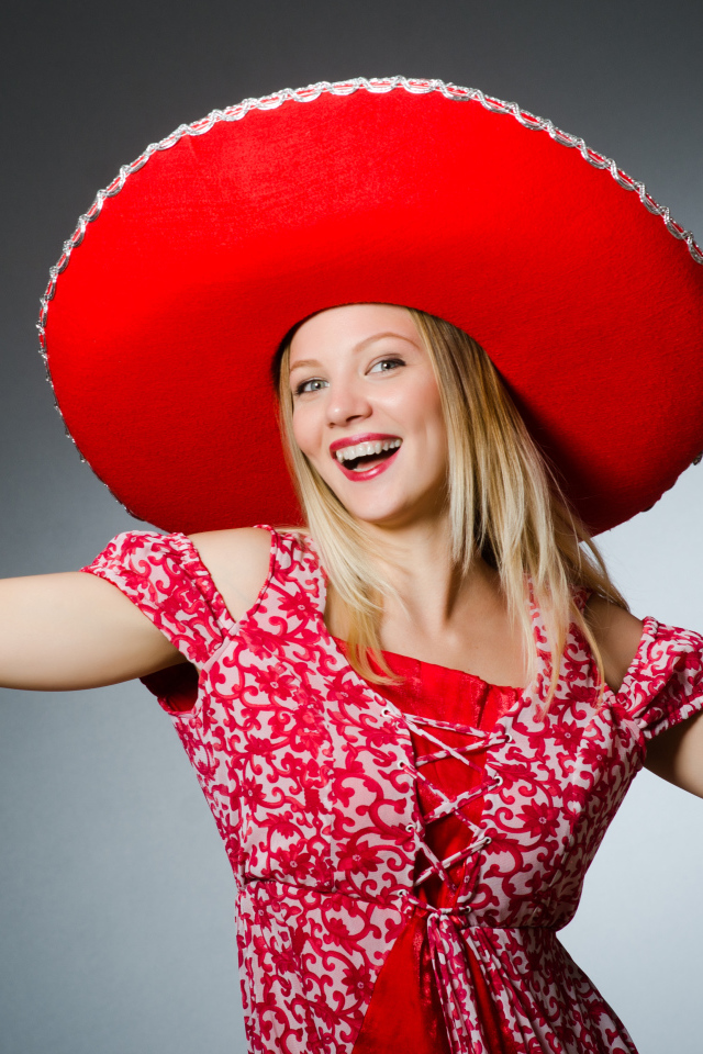 Красивая улыбающаяся блондинка в большой красной шляпе
