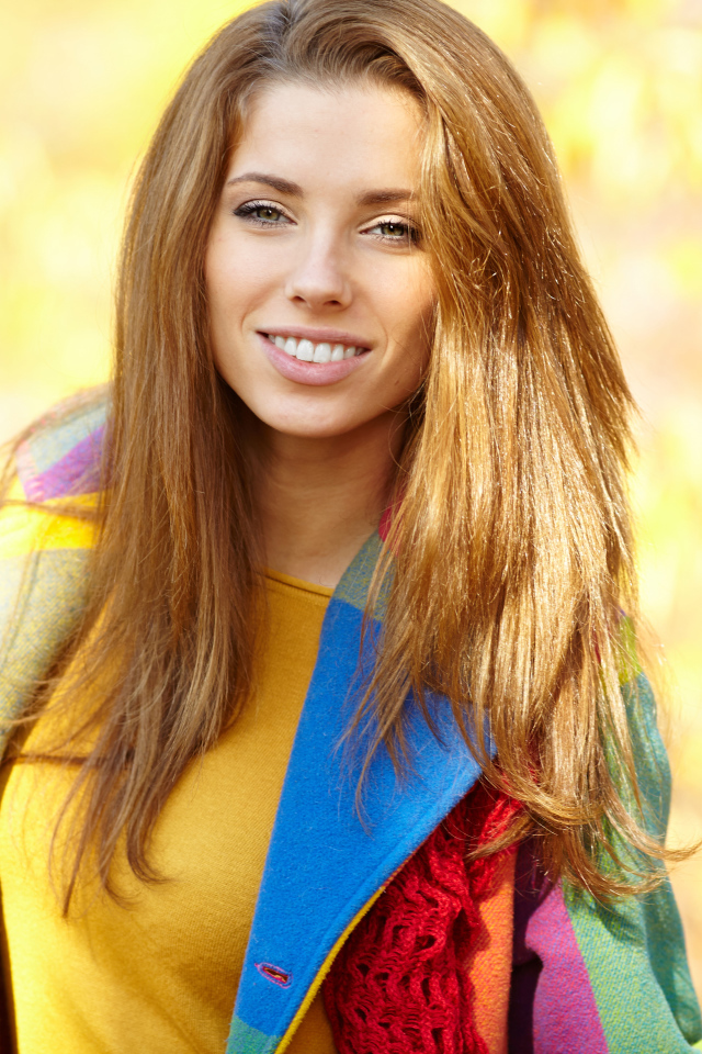 Красивая улыбающаяся шатенка в пальто 