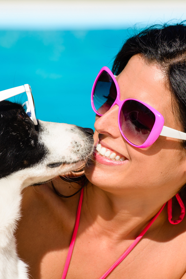 Красивая улыбающаяся девушка в солнечных очках с собакой 