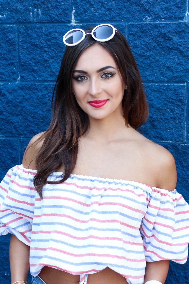 Красивая улыбающаяся девушка на фоне синей стены