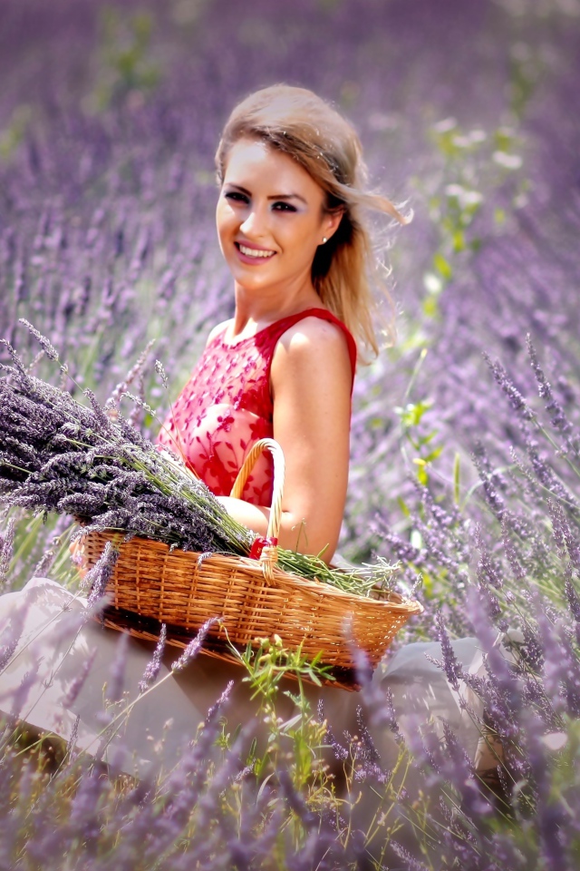Красивая улыбающаяся девушка с корзиной на лавандовом поле