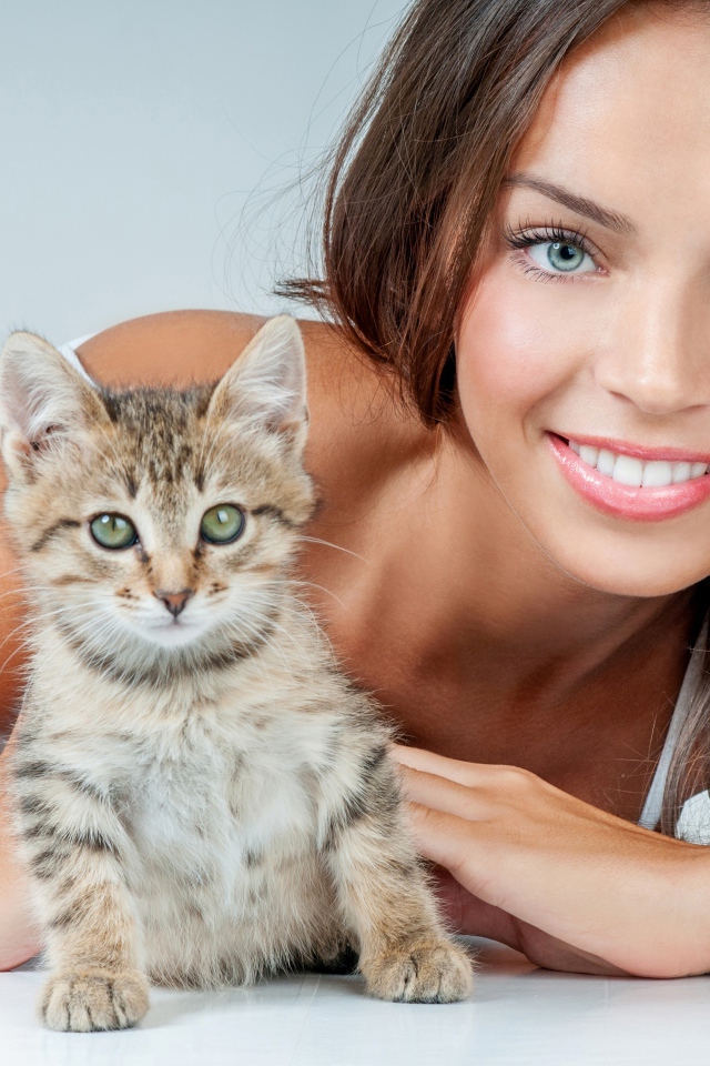 Красивая улыбающаяся девушка с серым котенком