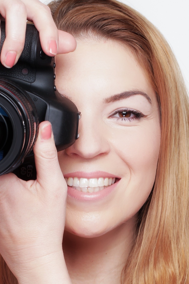 Красивая улыбающаяся девушка с фотоаппаратом
