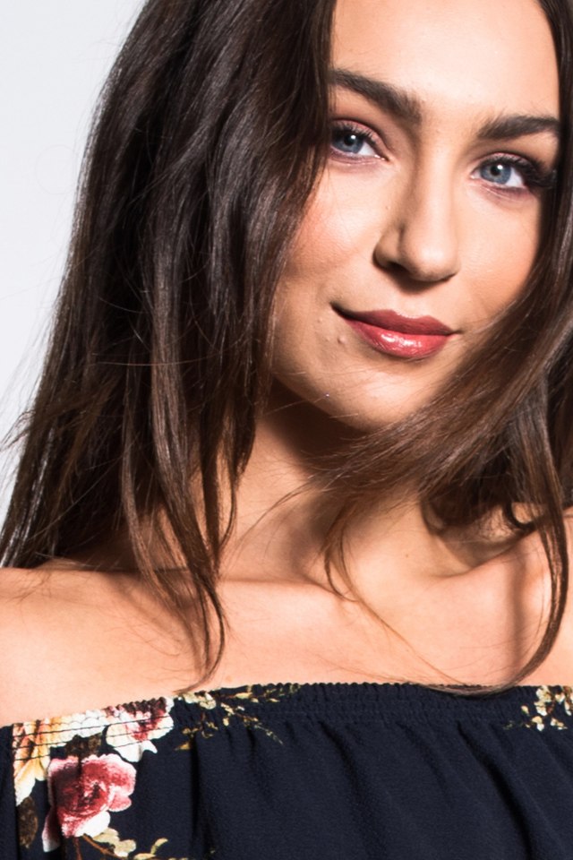 Красивая нежная голубоглазая брюнетка на сером фоне