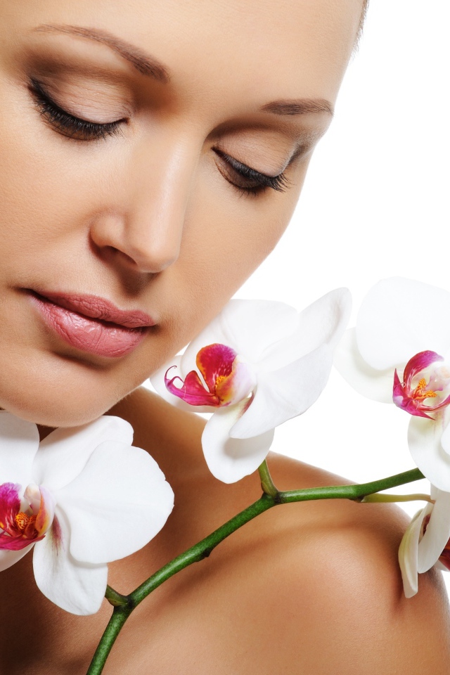 Красивая нежная девушка с цветами орхидеи на белом фоне