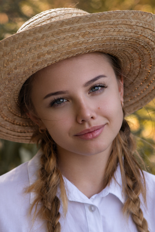 Красивая молодая девушка в соломенной шляпе