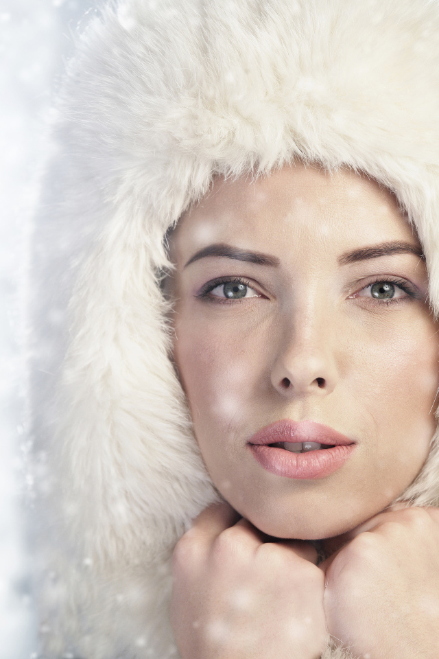 Красивая молодая девушка в белой зимней шапке 