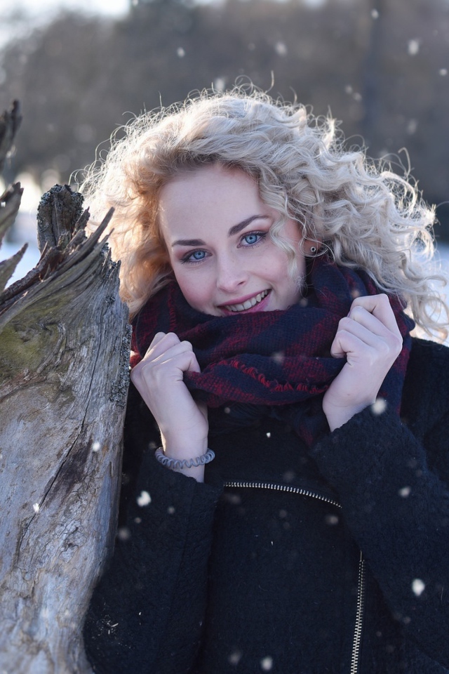 Голубоглазая блондинка у сухого дерева зимой