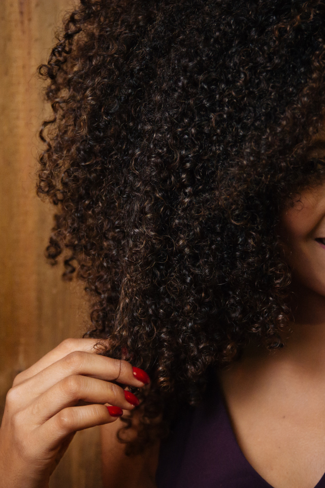 Кучерявая темнокожая девушка с красивой улыбкой 