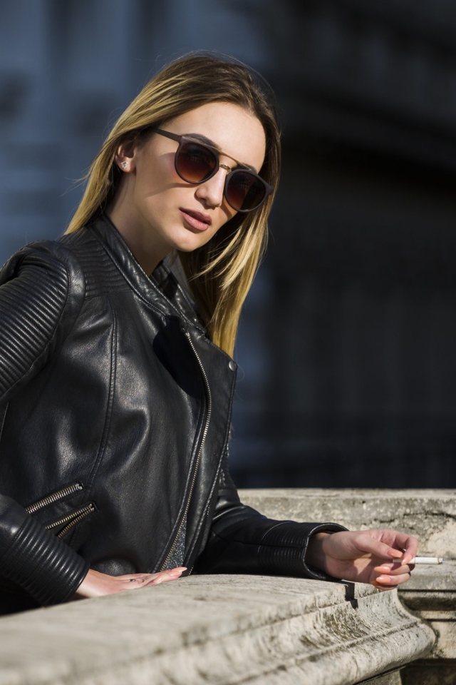 Дерзкая девушка в черной кожаной куртке и очках