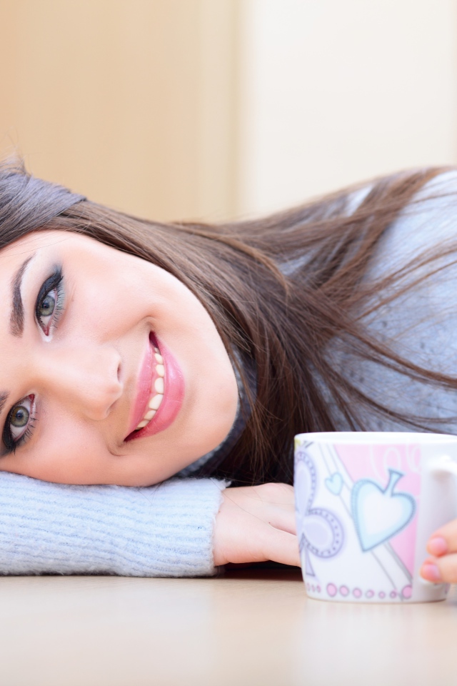 Нежная улыбающаяся девушка с чашкой