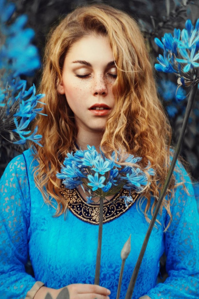 Мечтательная девушка с голубыми цветами 