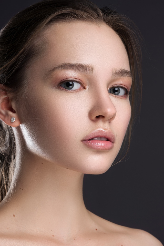 Нежная настоящая девушка шатенка на сером фоне