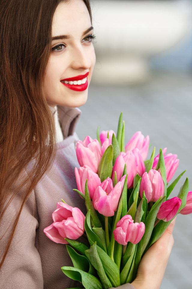 Нежная улыбающаяся девушка шатенка с букетом тюльпанов