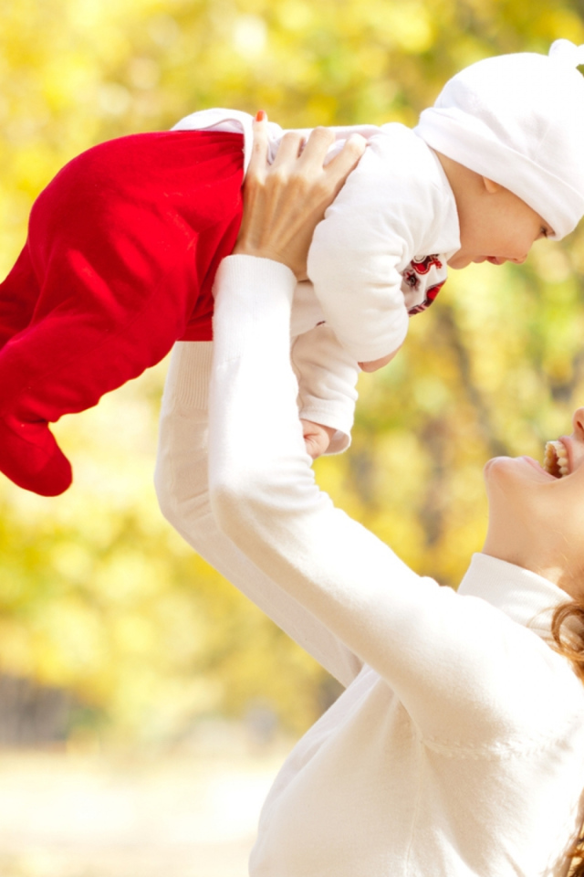 Счастливая девушка с младенцем на руках