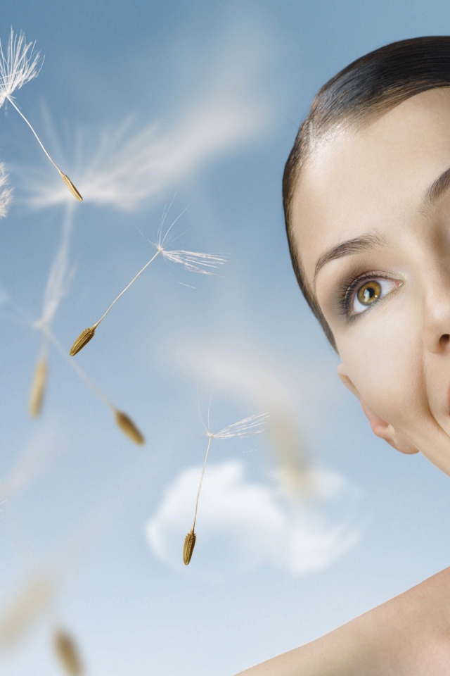 Счастливая девушка с одуванчиком в руке 