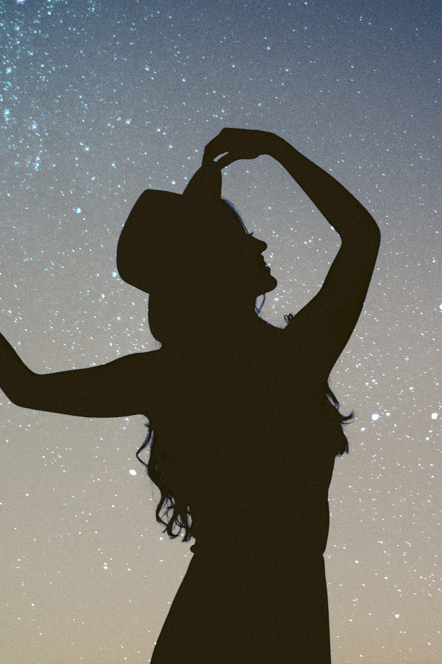 Силуэт девушки в шляпе на фоне неба