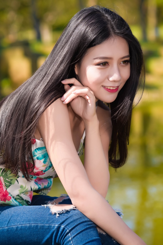 Улыбающаяся красивая девушка азиатка у воды