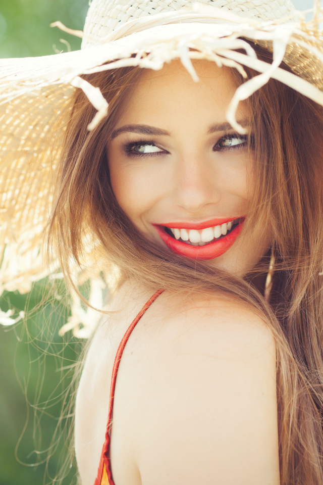Улыбающаяся девушка в соломенной шляпе летом