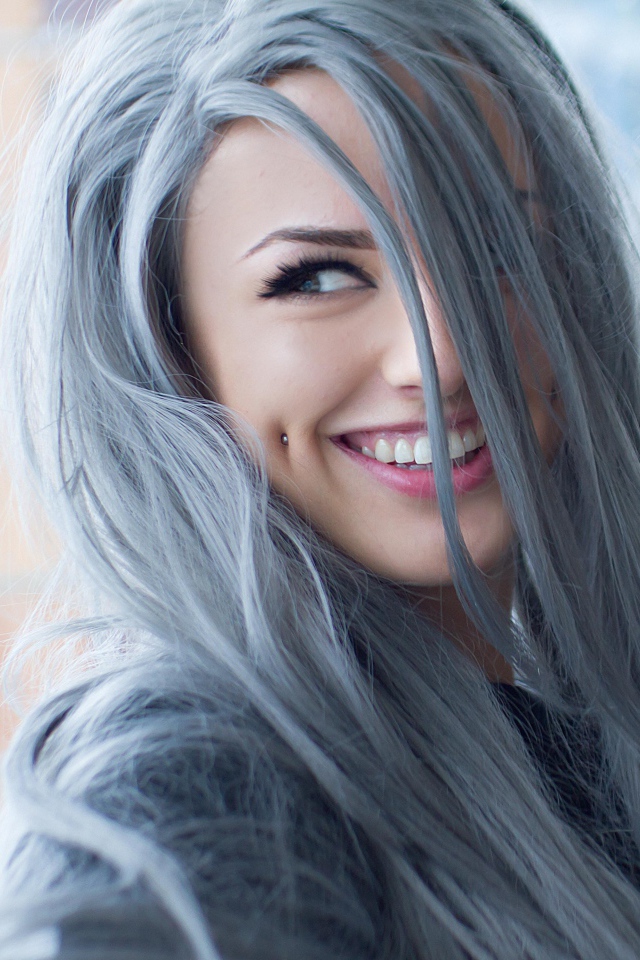 Улыбающаяся эпатажная девушка с пирсингом