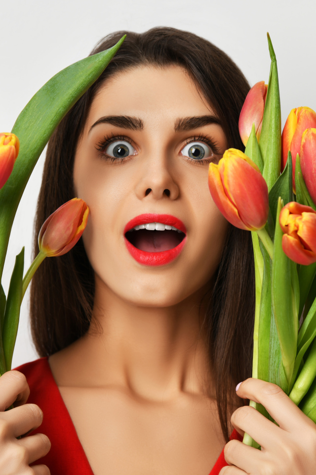 Удивленная шатенка с букетами тюльпанов