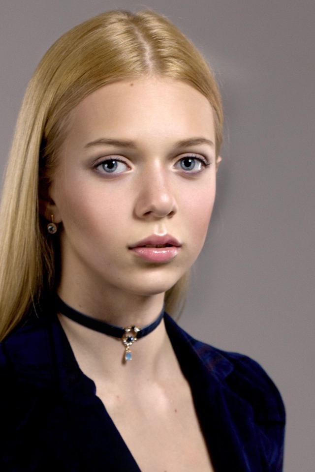 Нежная голубоглазая девушка с украшением на шее 