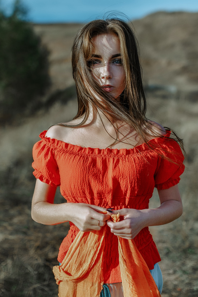 Ветер развивает волосы красивой девушке шатенке 