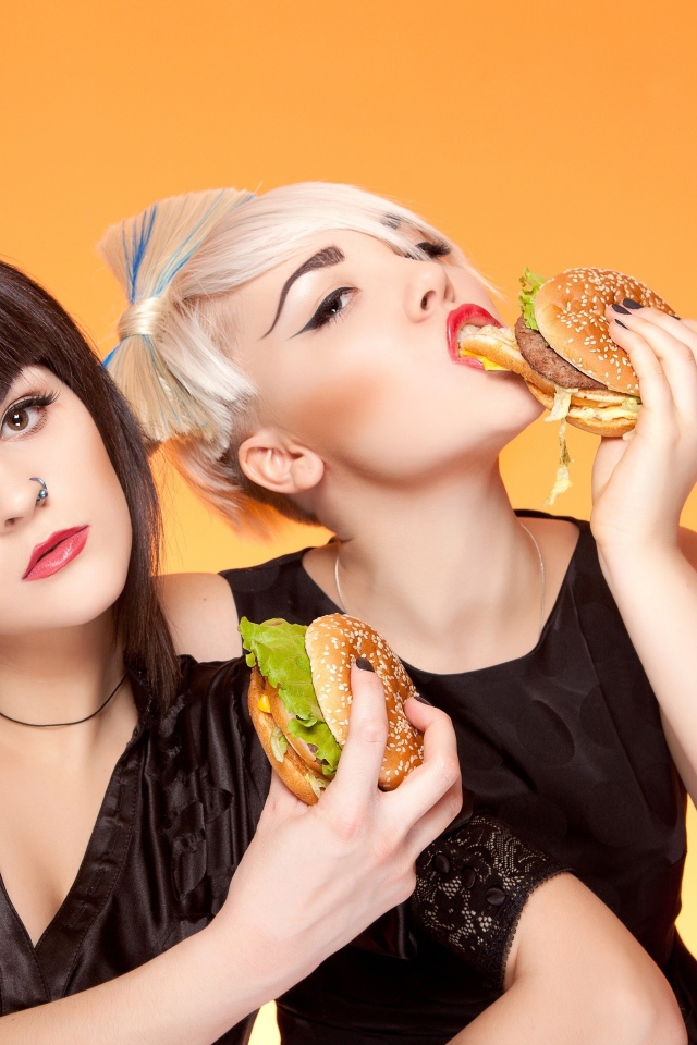 Две девушки с ярким макияжем с гамбургерами