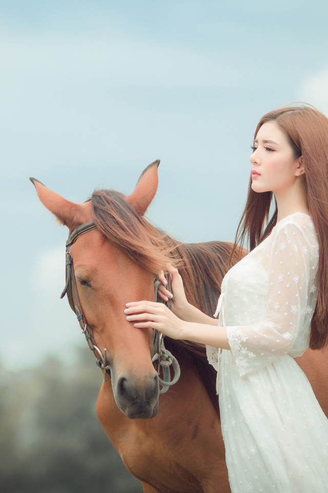 Молодая азиатка в белом платье с лошадью 