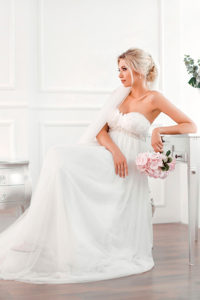 Молодая блондинка в красивом белом свадебном платье