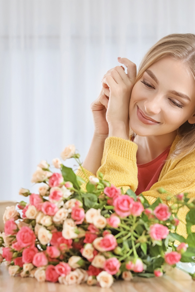 Молодая блондинка с букетом роз на столе