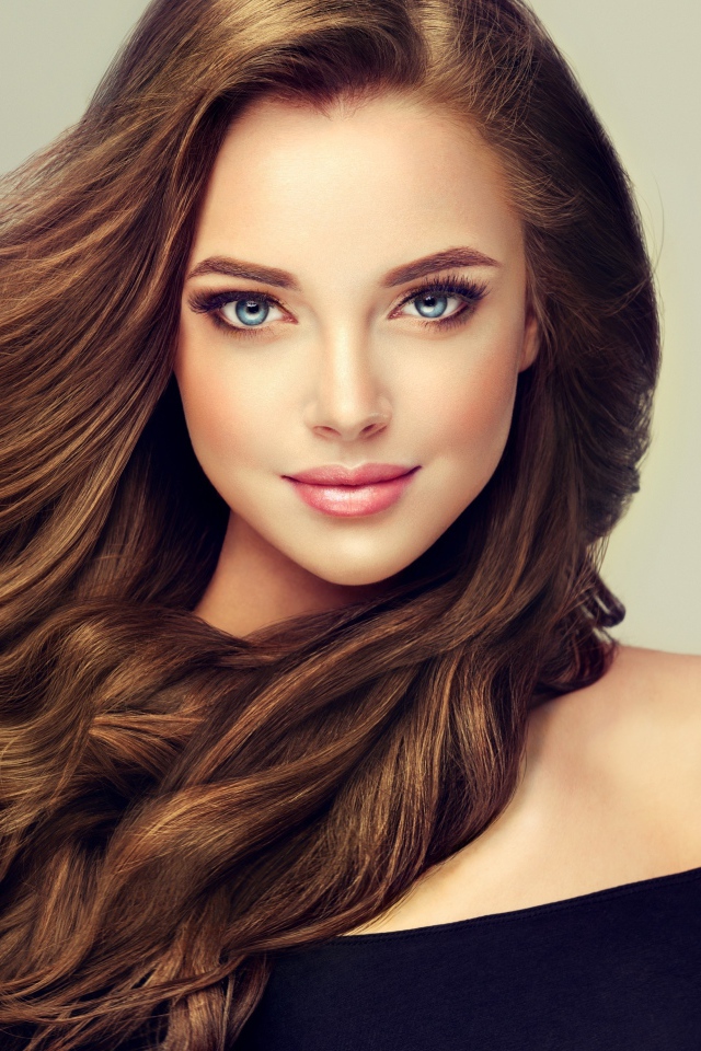 Молодая голубоглазая девушка с красивыми длинными волосами