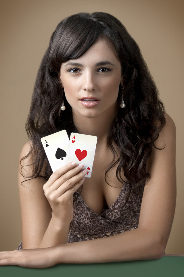 Молодая брюнетка с двумя карточными тузами в руке