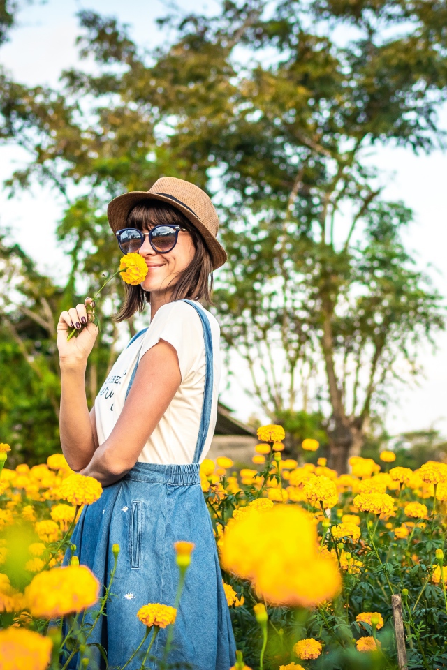Молодая девушка в солнечных очках в желтых цветах 