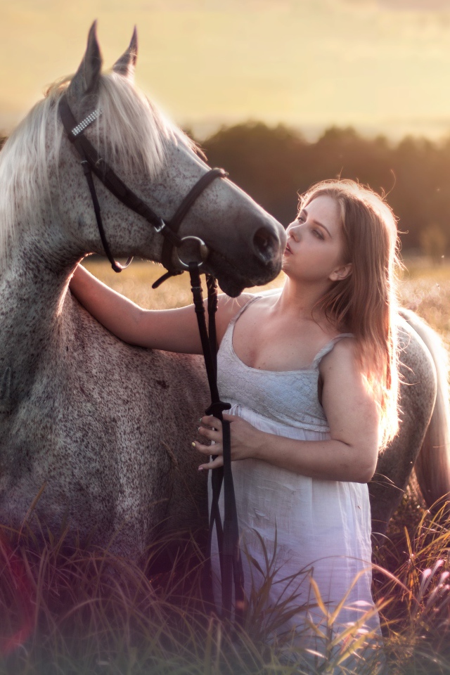 Молодая девушка с лошадью на поле